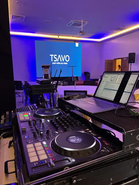 DJ controller and laptops set up in front of a Tsavo-branded screen